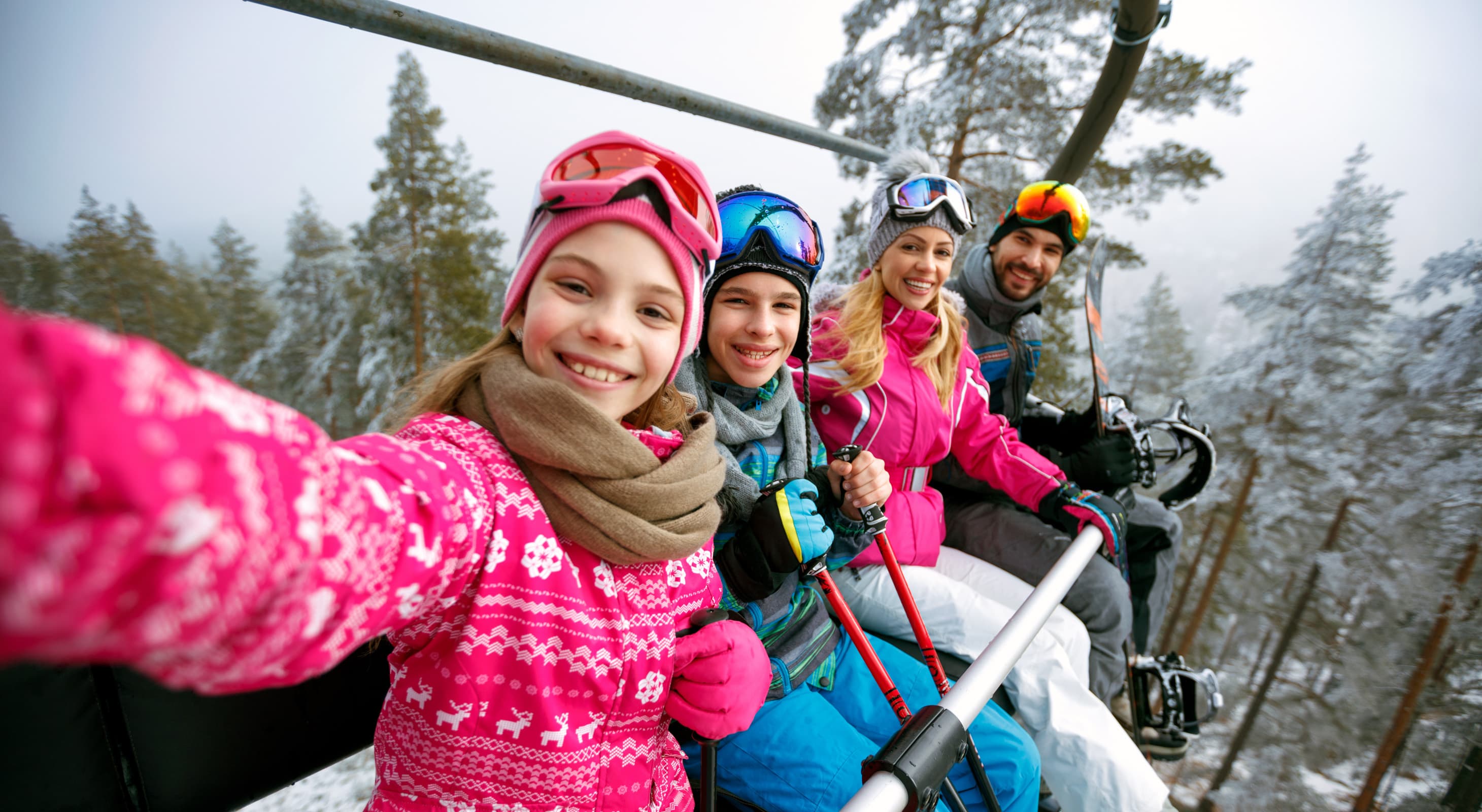 Happy family on ski lift smiling at camera in Vermont