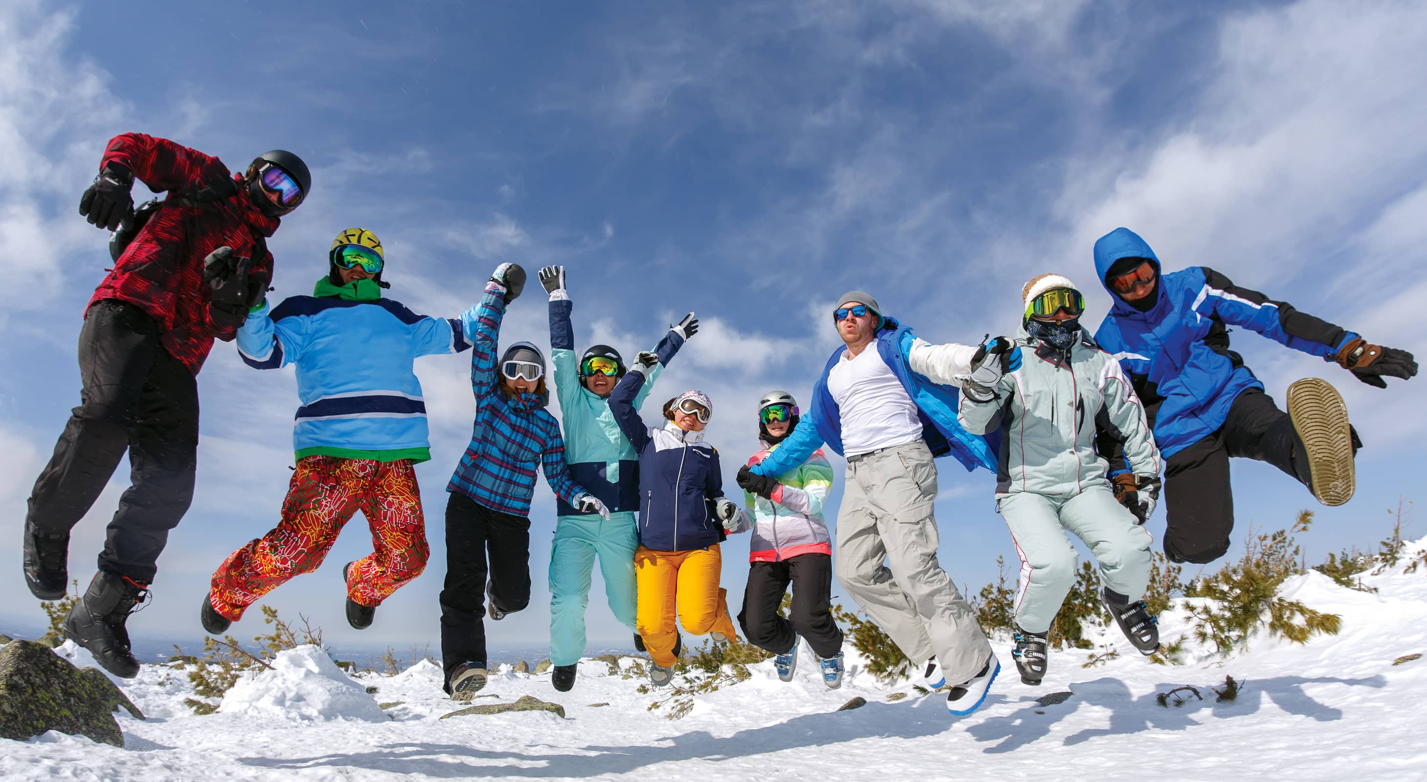 Group of friends jumping on ski slope