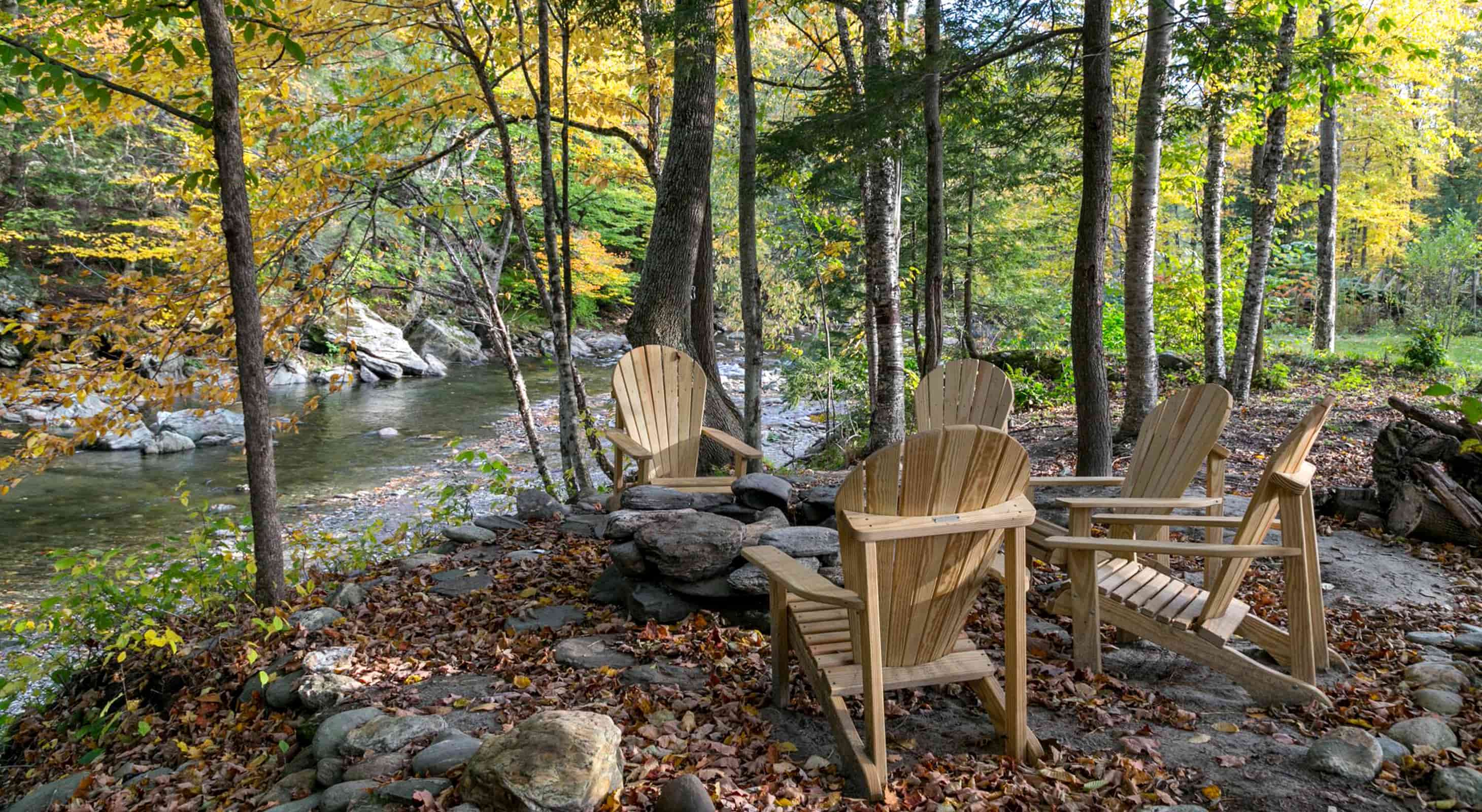 Relaxing chairs and fire pits at our riverfront Vermont lodge
