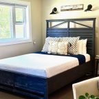 A queen-size bed and bar height table in the Riverside studio at Warren Lodge in VT