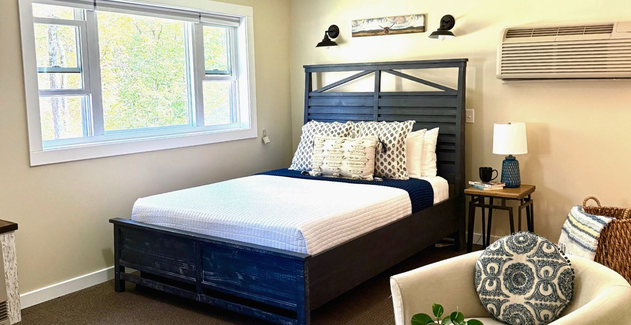 A queen-size bed and bar height table in the Riverside studio at Warren Lodge in VT