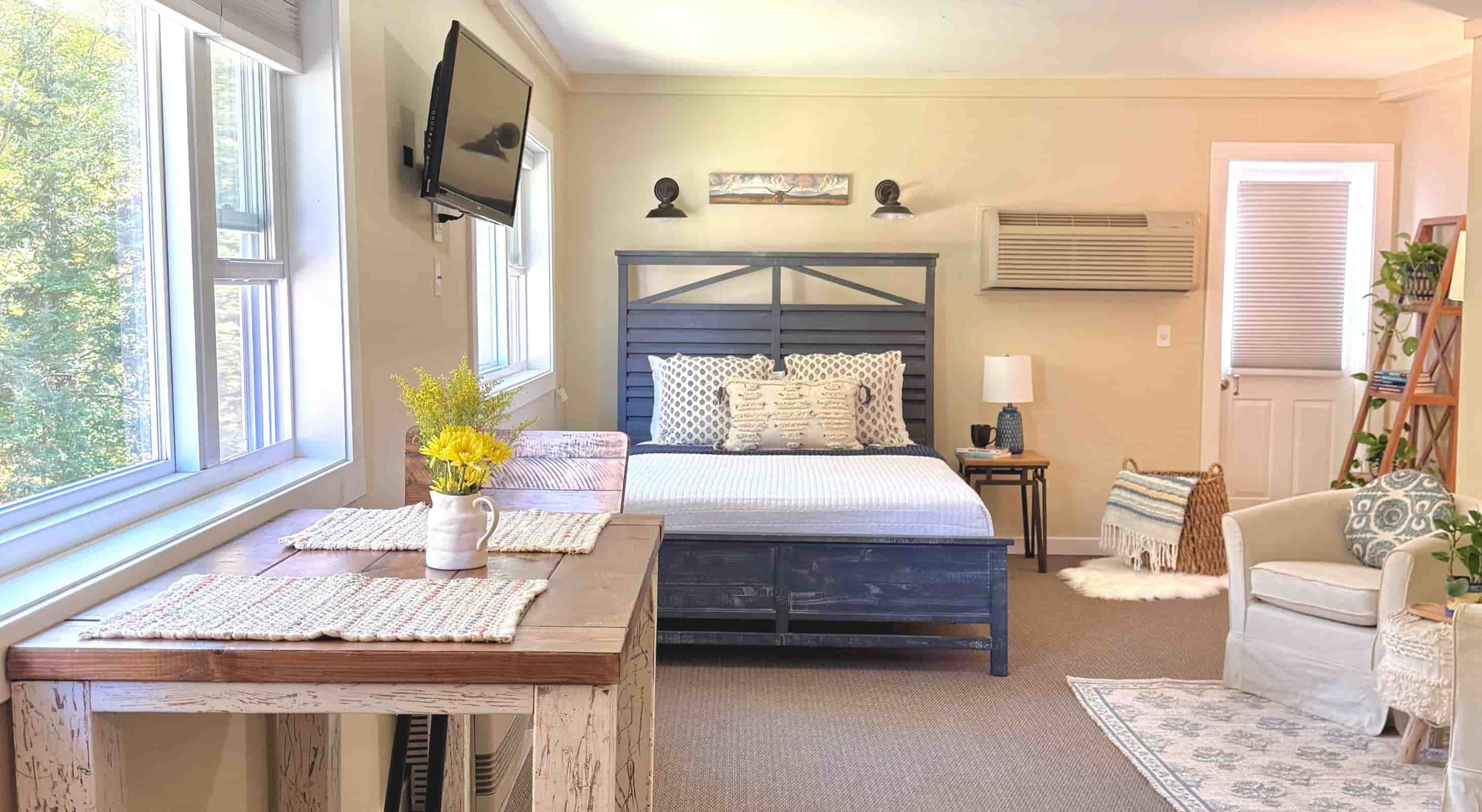 A queen-size bed and bar height table in the Riverside studio at Warren Lodge in VT